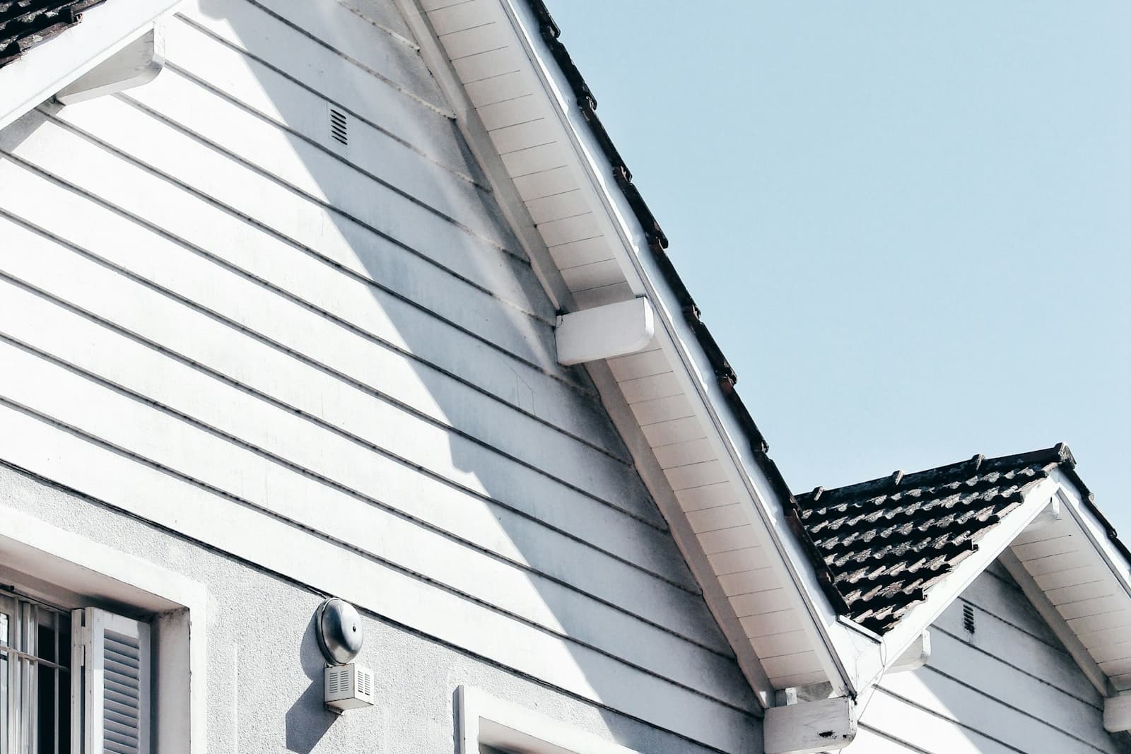 Painted horizontal wood lap siding and trim on the gable end of a house
